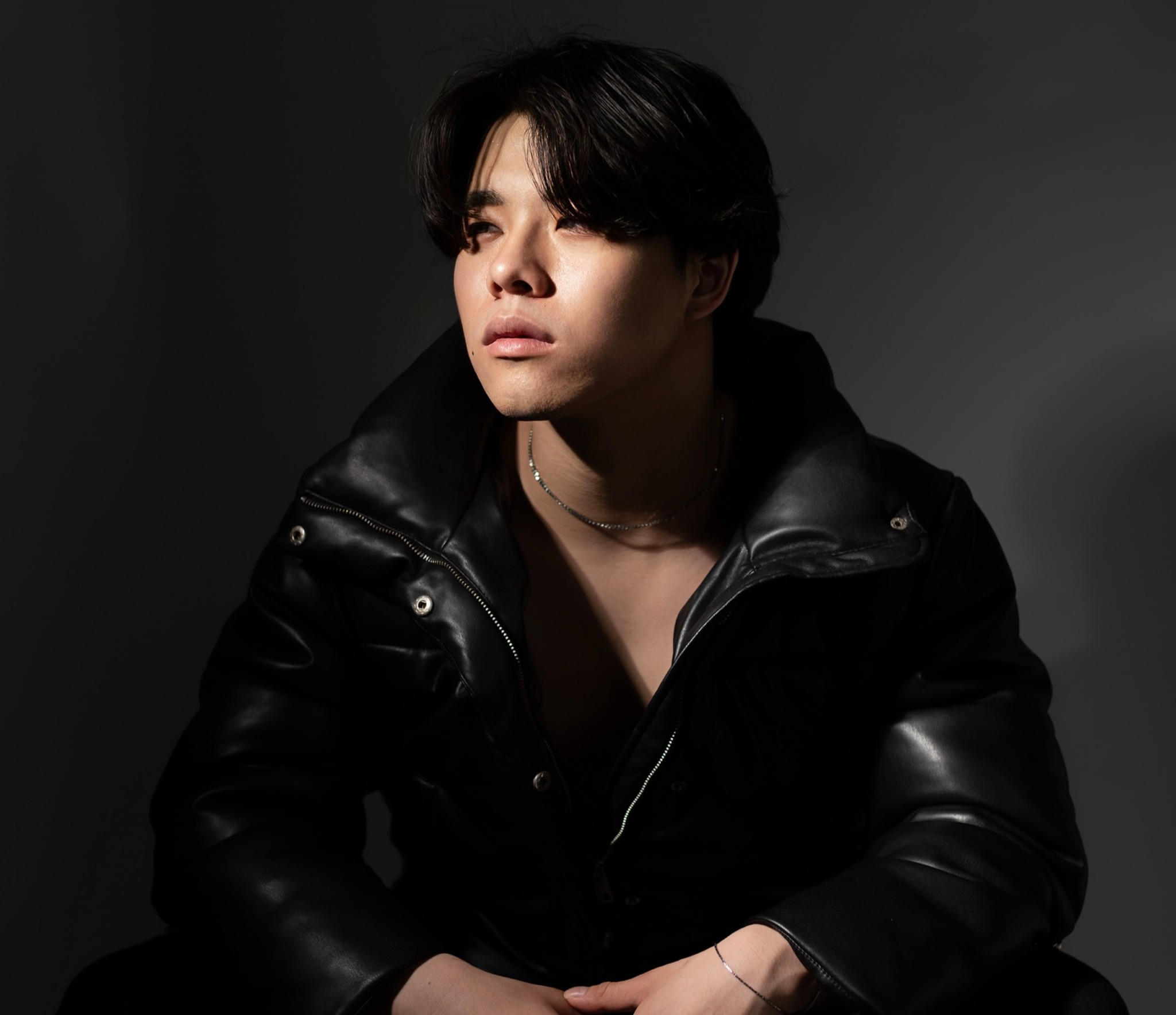 Jun Lucas in a black leather jacket, photographed in warm directional light